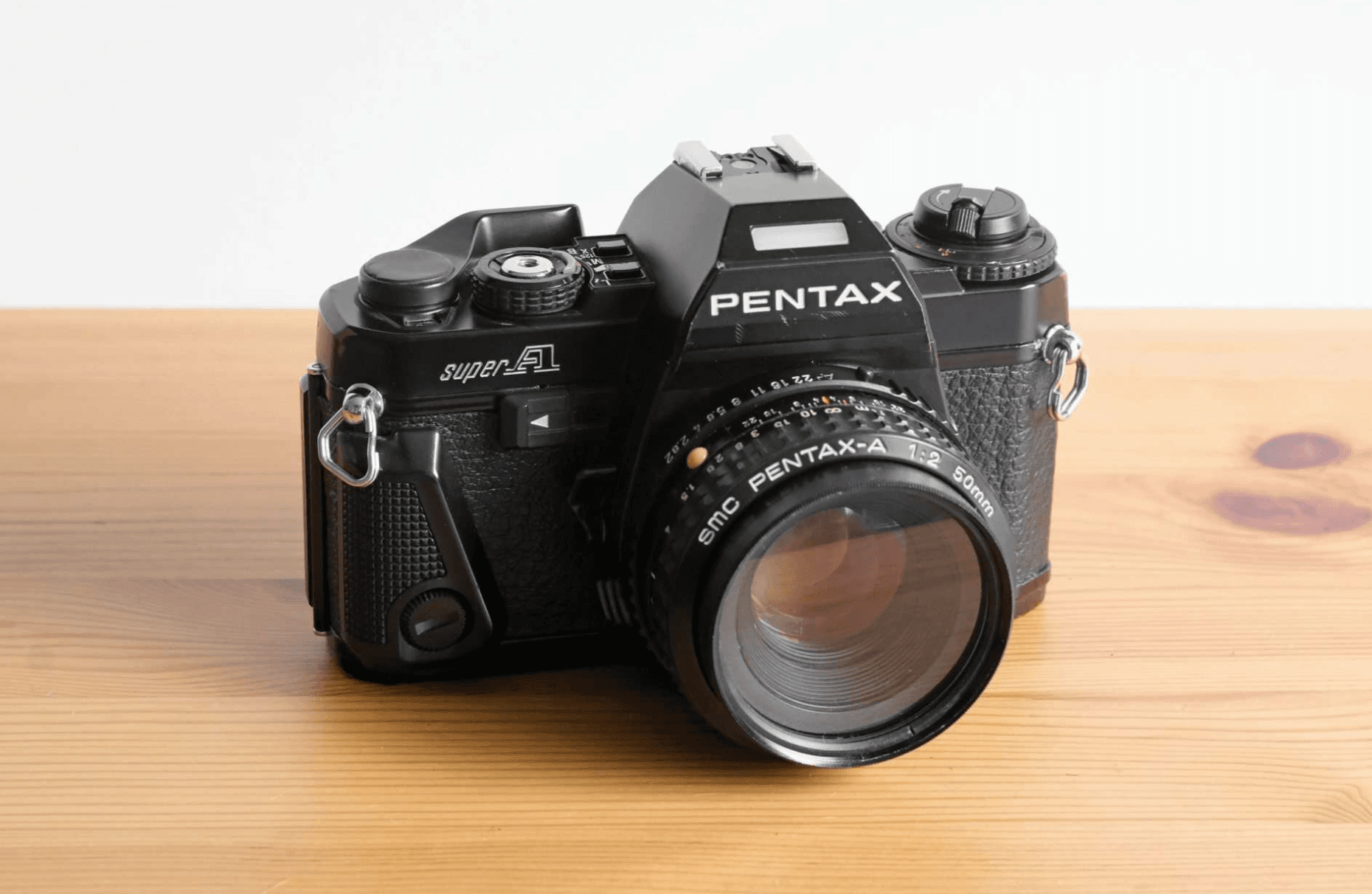 Front view of a black Pentax Super A 35mm SLR film camera with a 50mm lens.